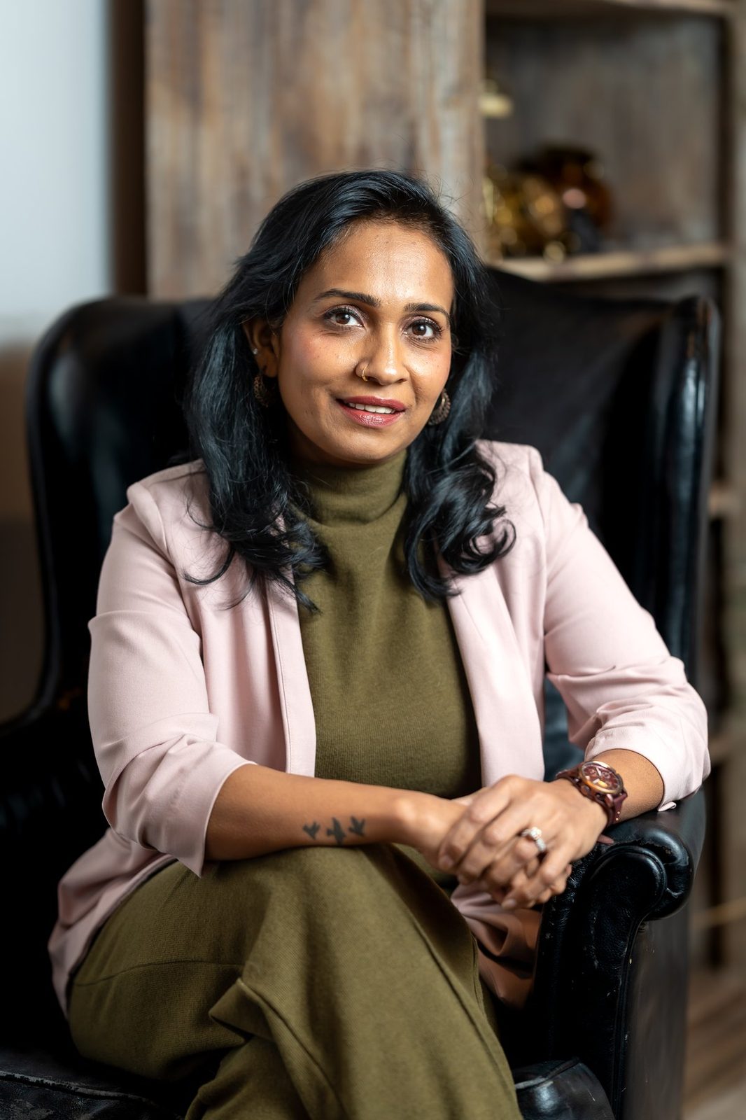 Sharmina Nasrin sitting and smiling in a pink blazer